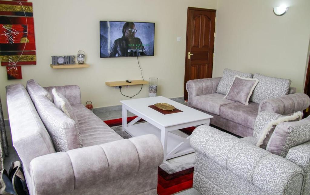 Sala de estar con 2 sofás y mesa en Lux Suites Milimani Luxe Apartments kisumu, en Kisumu