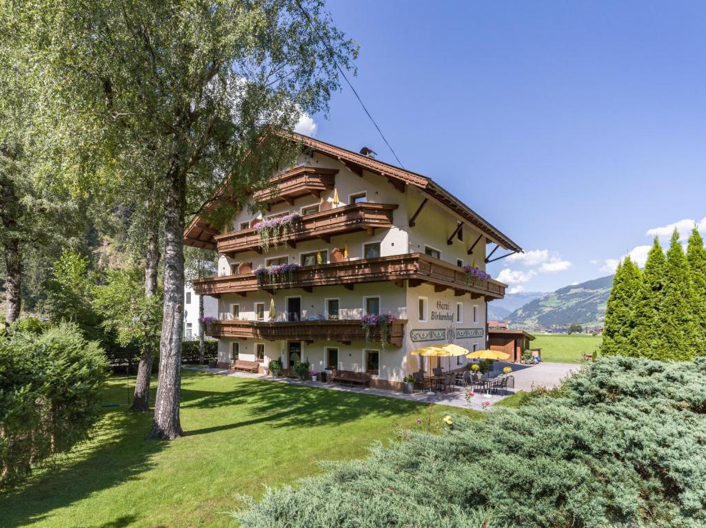 ein großes Gebäude auf einem Hügel mit Bäumen in der Unterkunft Hotel Garni Birkenhof in Mayrhofen