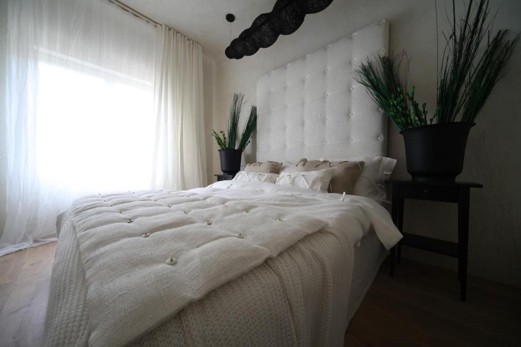1 dormitorio con 1 cama blanca grande y ventana en Strelnieku Avenue Apartment Jurmala, en Jūrmala