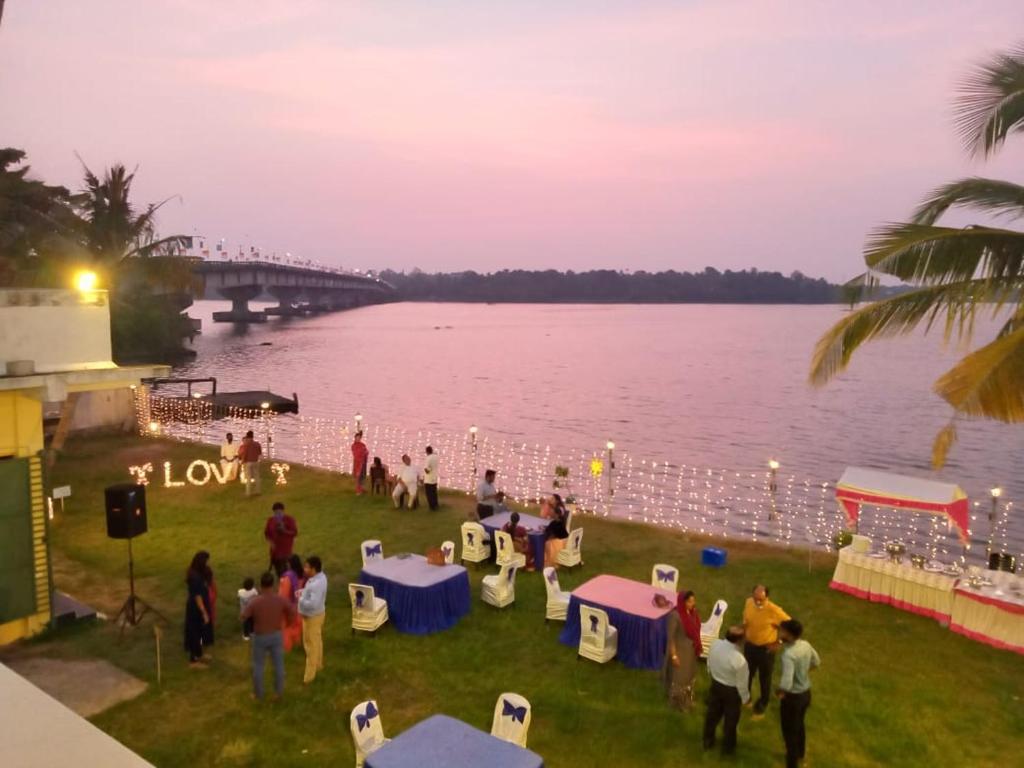 a group of people standing around a party by the water at Wind &Waves in Kollam