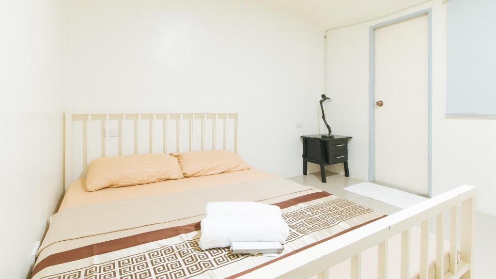 um quarto branco com uma cama e um espelho em Sonia Unidos Mangroves Garden Resort em San Francisco