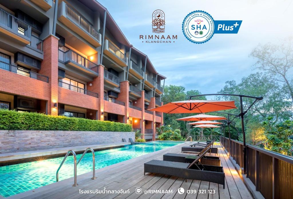 a patio area with a pool, chairs, and tables at Rimnaam Klangchan Hotel - SHA Plus in Chanthaburi