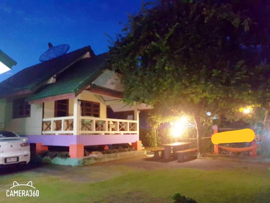 a house at night with a table in front of it at บ้านสุขกมลแววดาวบ้านเดี่ยว1ห้องนอน in Ban Pak Nam