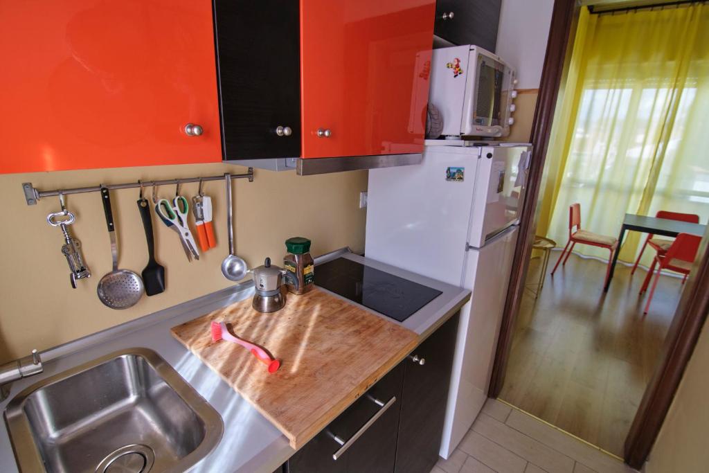 a small kitchen with a sink and a refrigerator at La Casetta del Viaggiatore - "Traveller's Home" in Torre del Lago Puccini