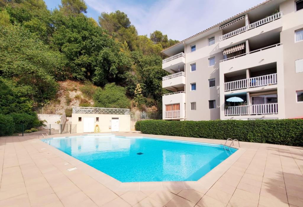 une piscine en face d'un bâtiment dans l'établissement Appartement avec piscine proche bord de mer, à Cagnes-sur-Mer