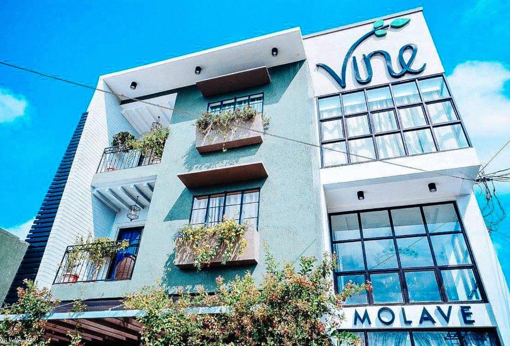 un bâtiment avec un panneau sur son côté dans l'établissement RedDoorz @ Vine Molave, à Molave