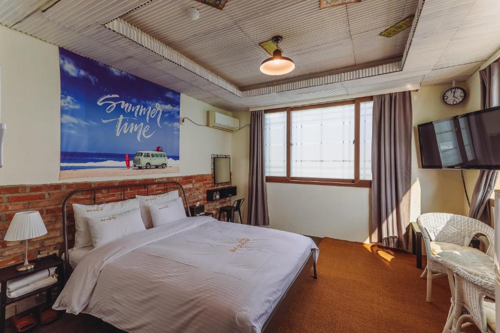 um quarto com uma cama grande e uma televisão em Residence Hotel Blue Ocean View em Ulsan