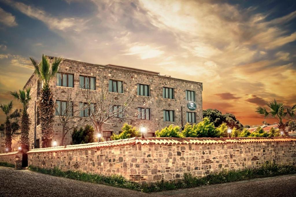 um edifício com uma parede de pedra em frente em CUNDA AKSAÇ OTEL em Ayvalik