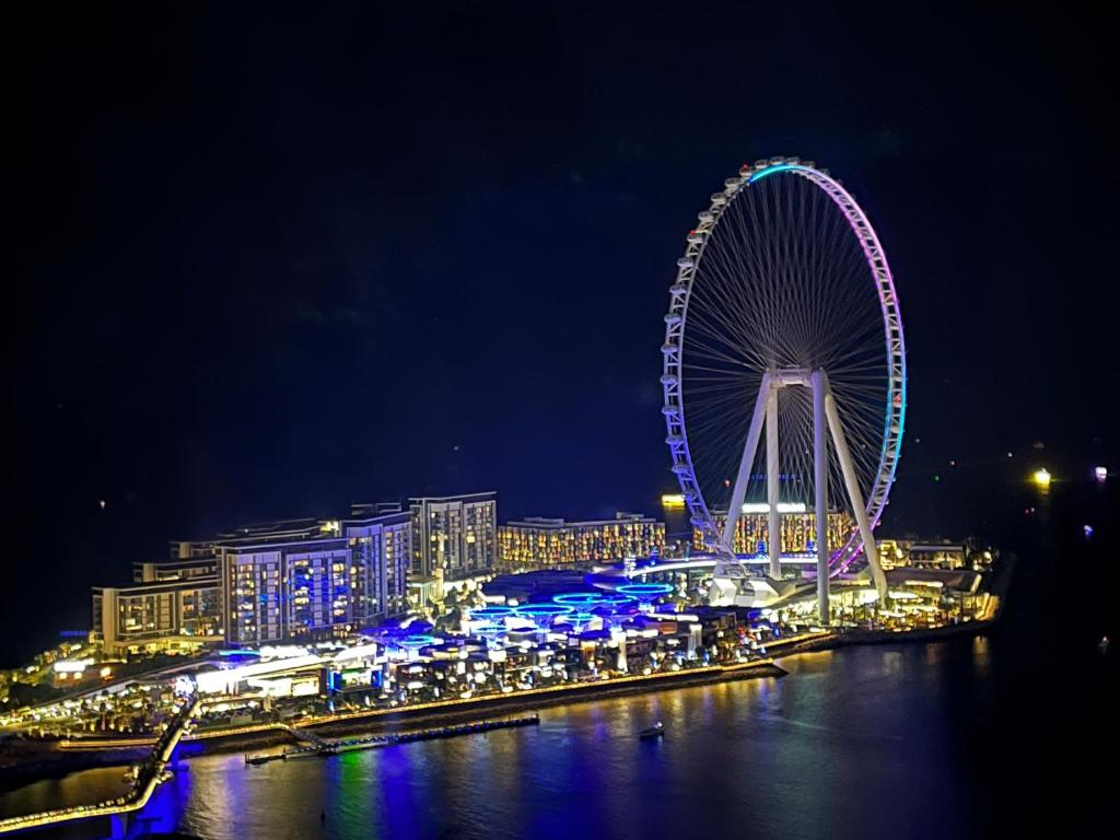 une grande roue ferris dans une ville la nuit dans l'établissement Beautiful apartment with amazing sea views, à Dubaï