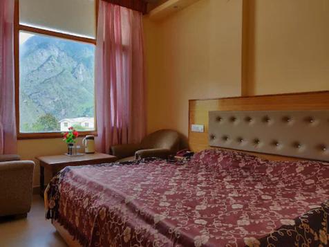 ein Schlafzimmer mit einem großen Bett und einem Fenster in der Unterkunft HOTEL MOUNTAIN VIEW in Jyotirmath