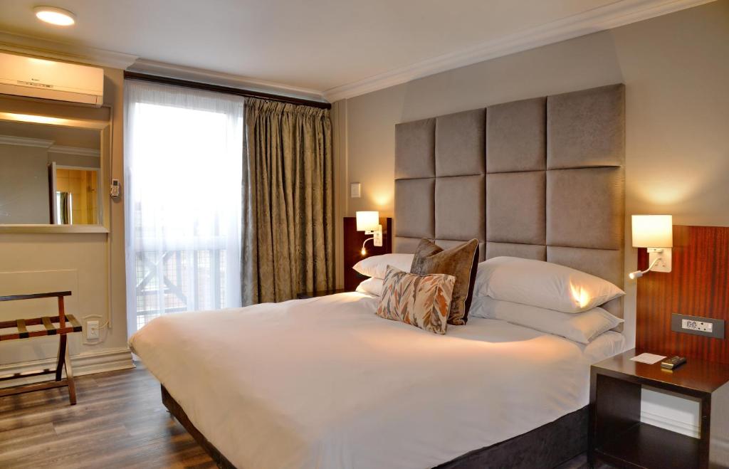 a bedroom with a large bed and a large window at ANEW Hotel Centurion Pretoria in Centurion