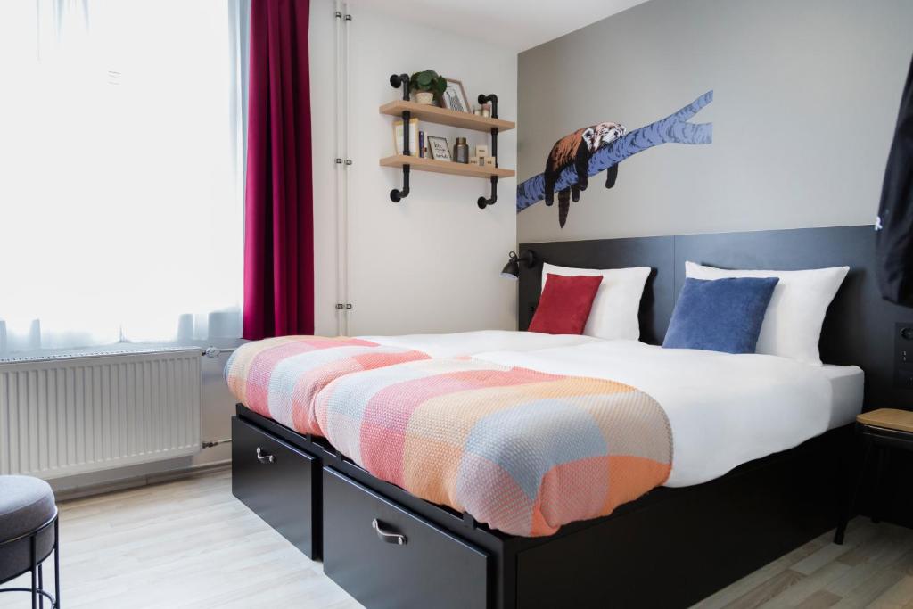 a bedroom with a large bed with colorful blankets and pillows at Generator Hamburg in Hamburg