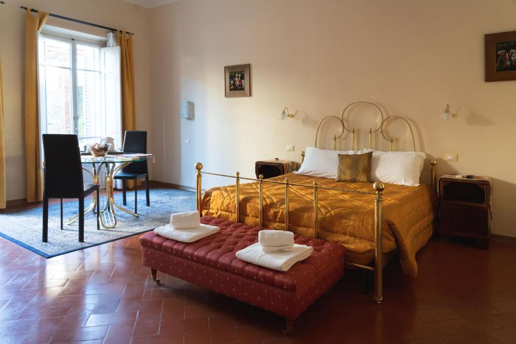 a bedroom with a bed and a table and a chair at Relais Accademia in Florence