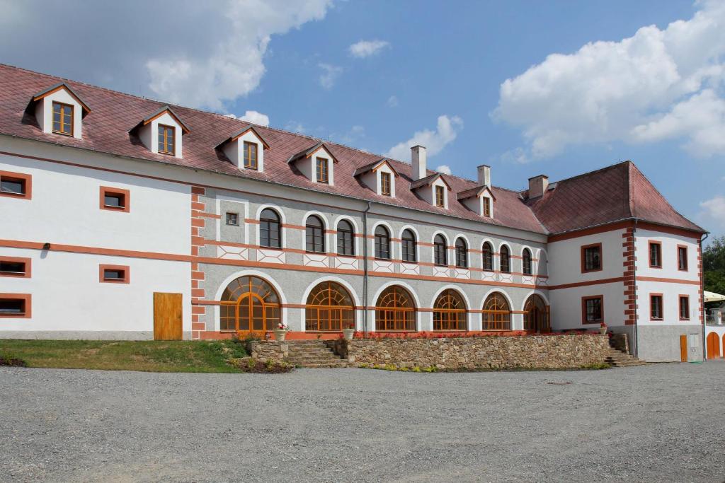a large white building with a red roof at Zámek Libouň in Louňovice pod Blaníkem