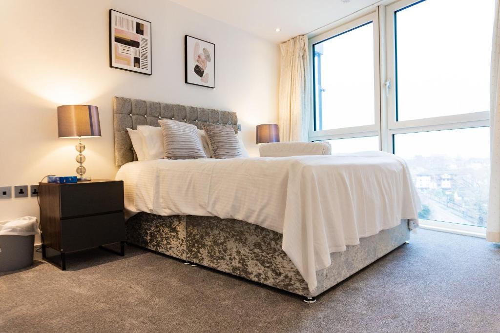 um quarto com uma cama grande e uma janela grande em GWQ Apartments Luxe em Portsmouth