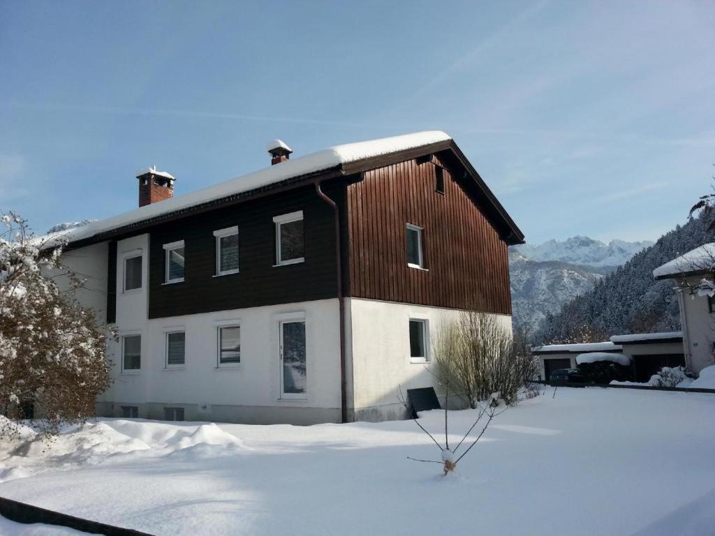 a large house with snow on the ground at Ferienwohnung Wertenauer in Kiefersfelden