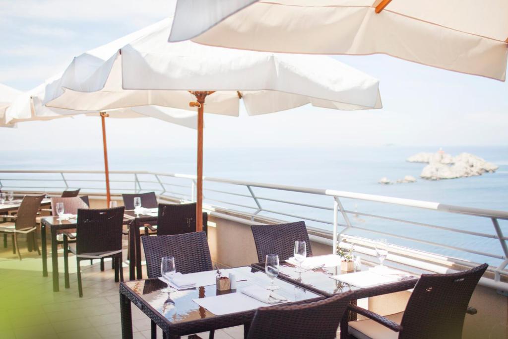 a restaurant with tables and umbrellas on a ship at Hotel Dubrovnik Palace in Dubrovnik
