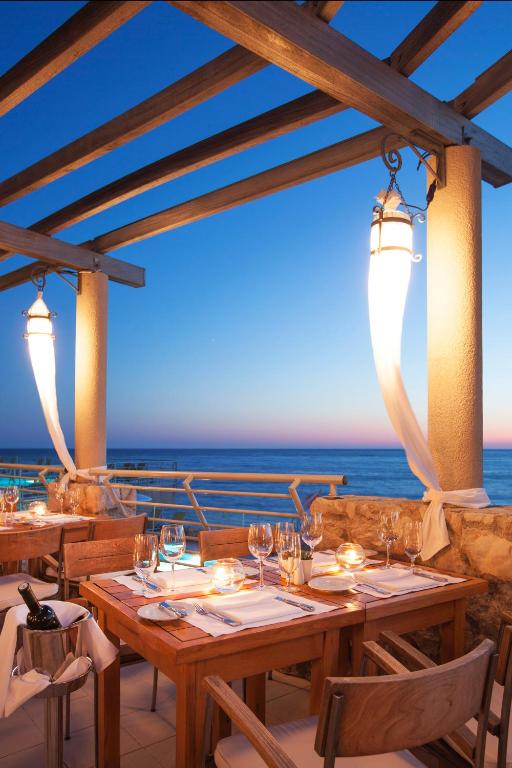 a restaurant with a table with the ocean in the background at Hotel Dubrovnik Palace in Dubrovnik