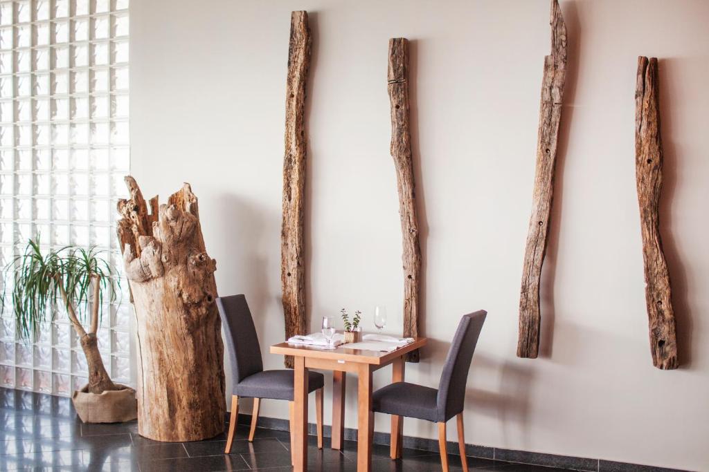 a table and chairs in front of a wall with trees at Hotel Dubrovnik Palace in Dubrovnik