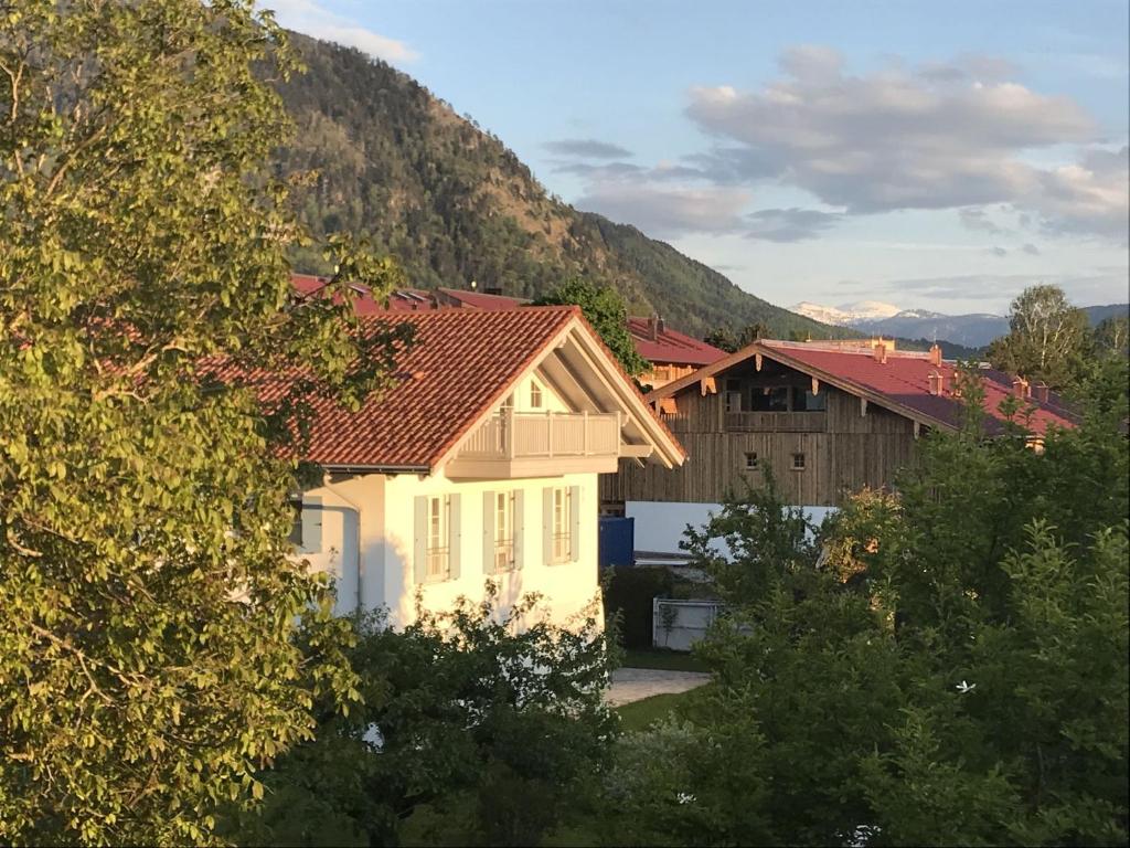 une maison blanche avec un toit rouge et quelques arbres dans l'établissement Haus Vincent, à Grassau