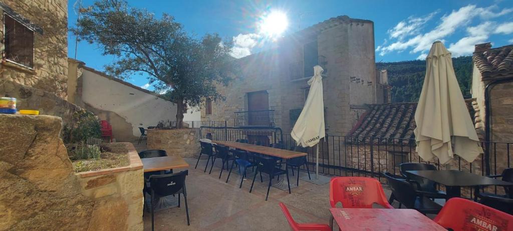 a patio with tables and chairs with the sun shining at El Mijares in Olba