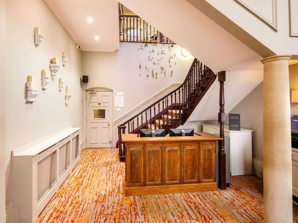 a large staircase leading up to a living room at Mercure Bristol North The Grange Hotel in Bristol