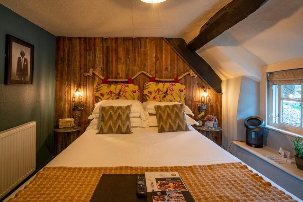 a bedroom with a large bed with wooden walls at Castle Inn in West Lulworth