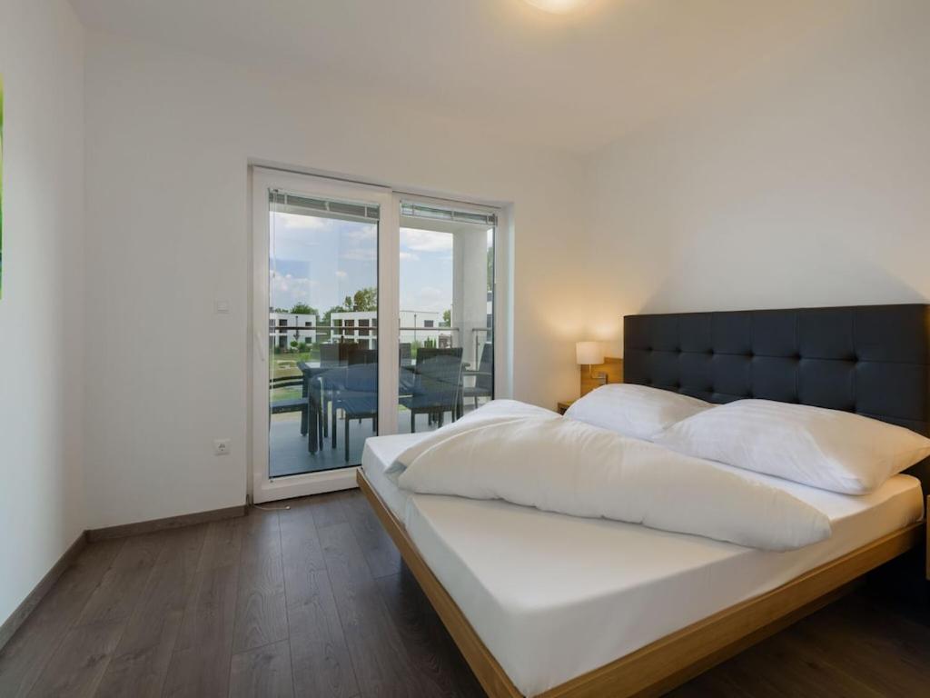 sypialnia z dużym łóżkiem i balkonem w obiekcie Relaxing Apartment Stay in Zsira w mieście Zsira