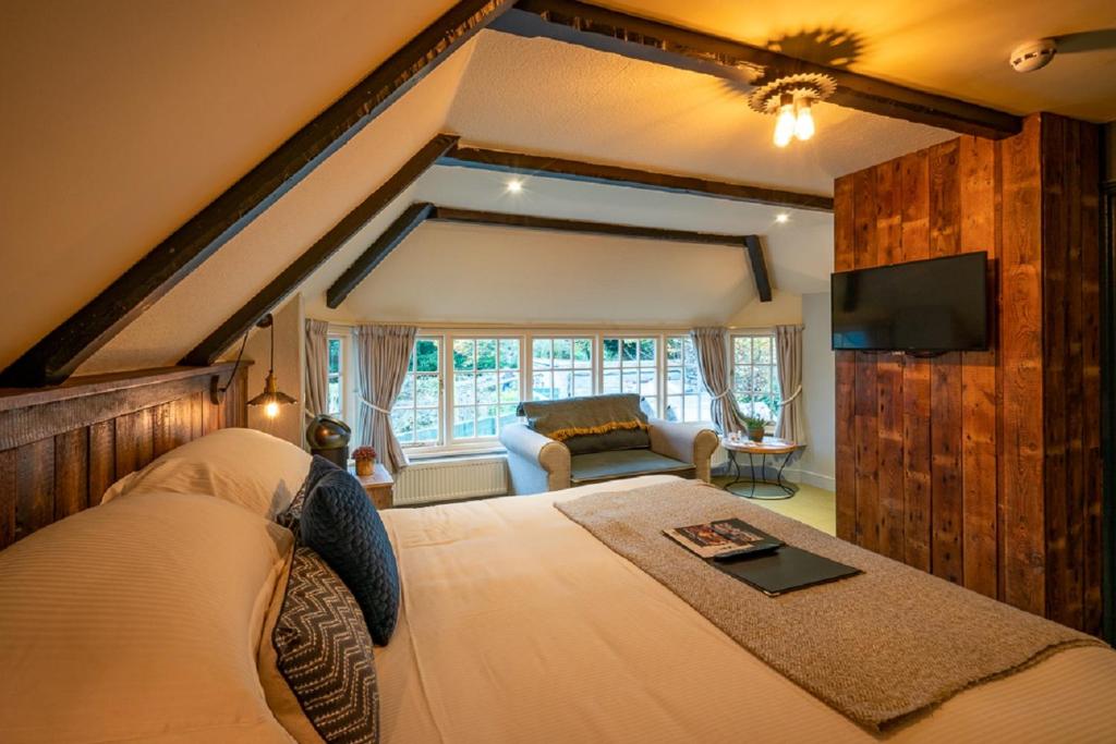 a bedroom with a bed and a tv and a couch at Castle Inn in West Lulworth