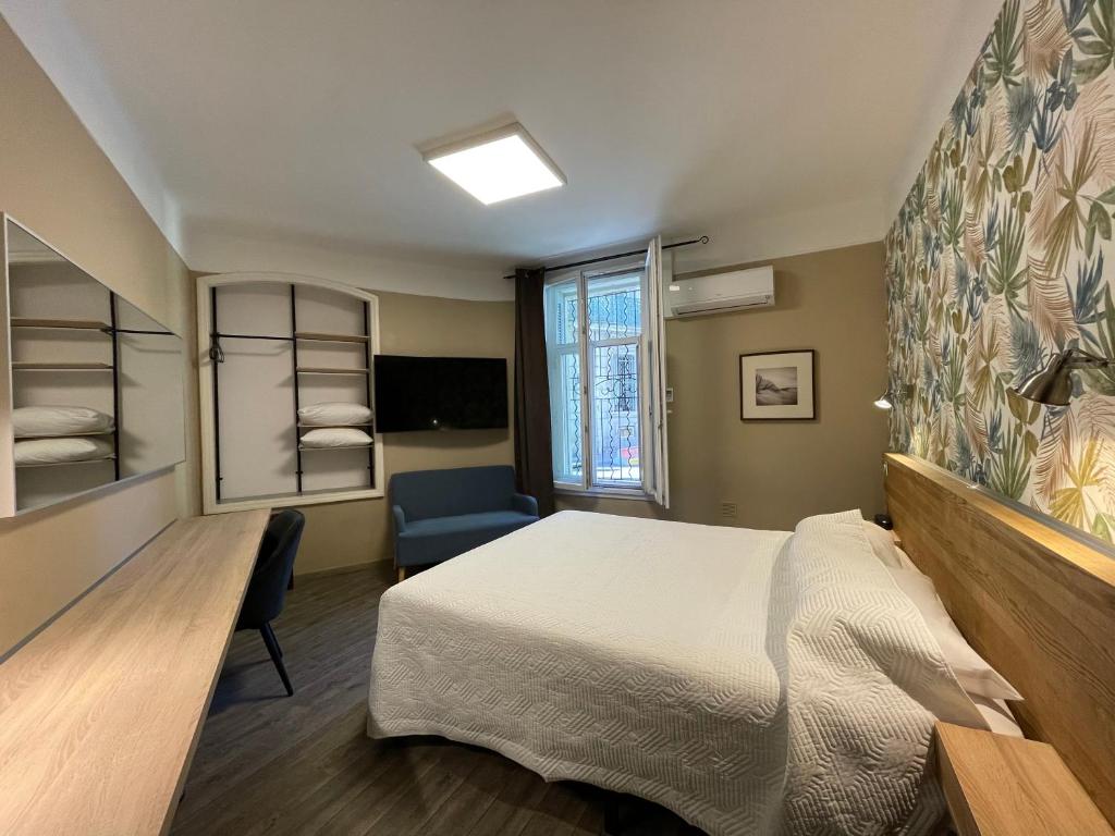 a bedroom with a bed and a desk and a chair at Hôtel Mistral Comédie Saint Roch in Montpellier