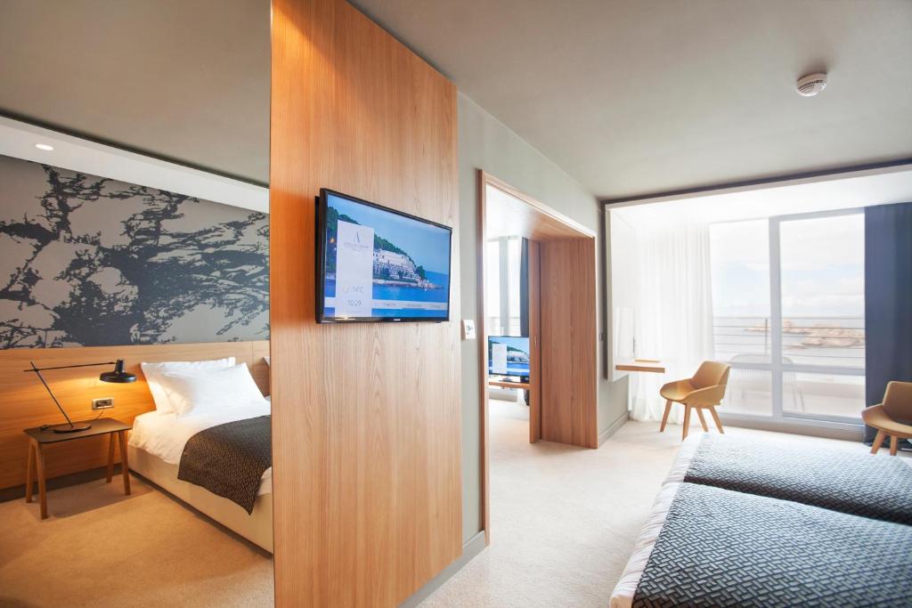 a hotel room with a bed and a flat screen tv at Hotel Dubrovnik Palace in Dubrovnik