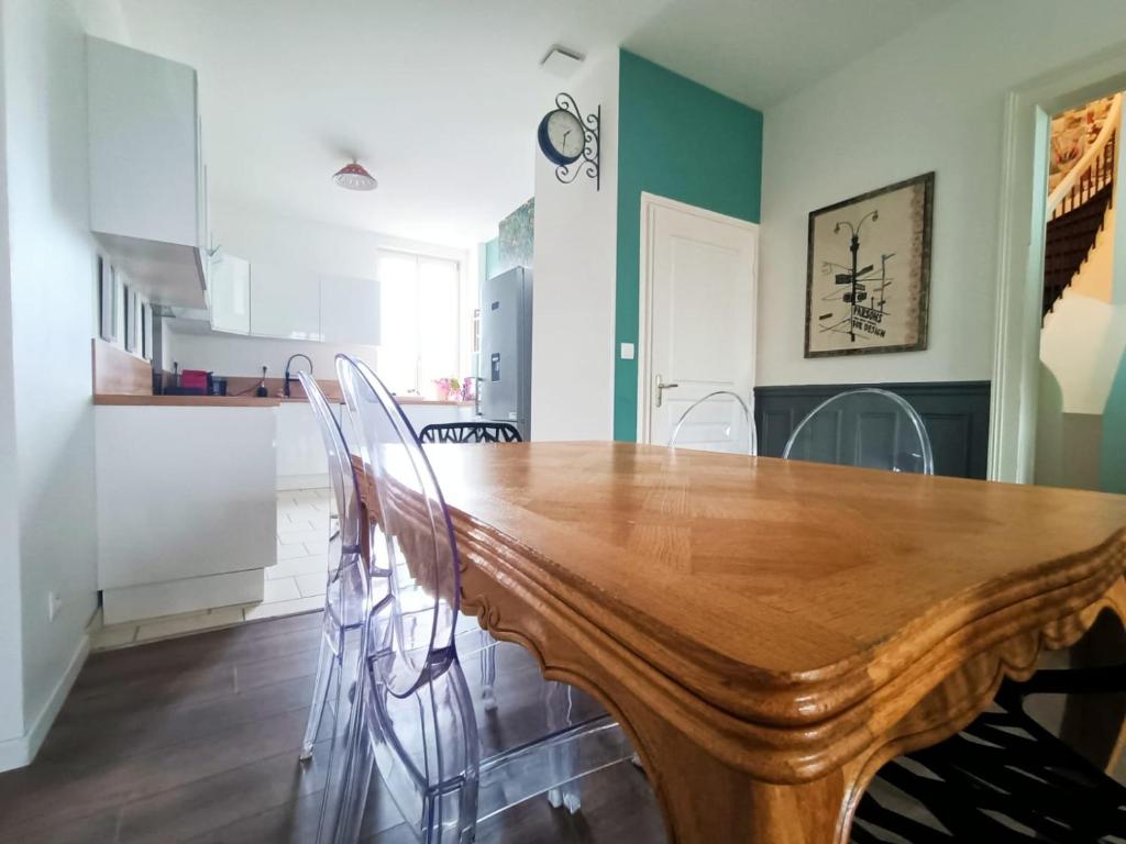 - une salle à manger avec une table et des chaises en bois dans l'établissement Magnifique appartement proche centre-ville et gare chemin du barrage, à Châlons-en-Champagne