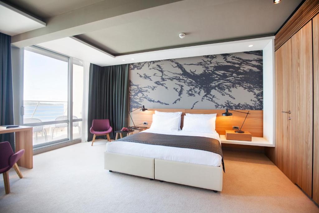 a bedroom with a bed and a large wall at Hotel Dubrovnik Palace in Dubrovnik