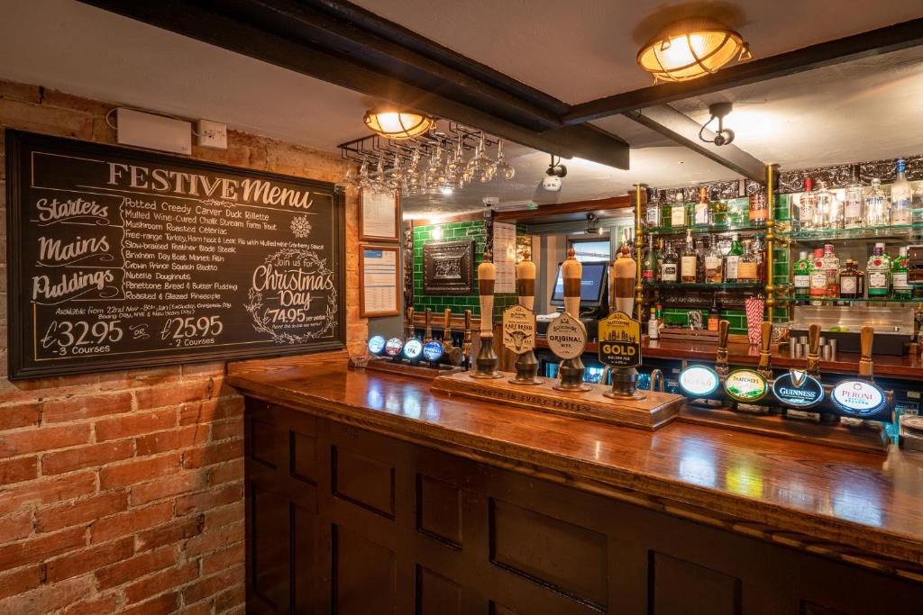 a bar with a wooden counter and a chalkboard at Castle Inn in West Lulworth