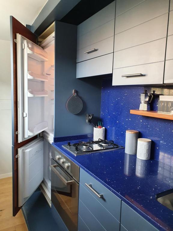 a kitchen with blue counter tops and white cabinets at Paradise Penthouse Suite Amazing View in Rome