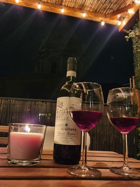 a bottle of wine and two glasses on a table at Paradise Penthouse Suite Amazing View in Rome