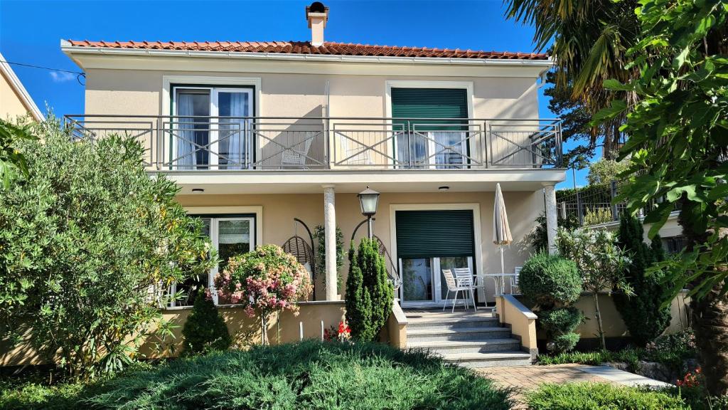 a villa with a balcony and a porch at Apartments Biba in Malinska
