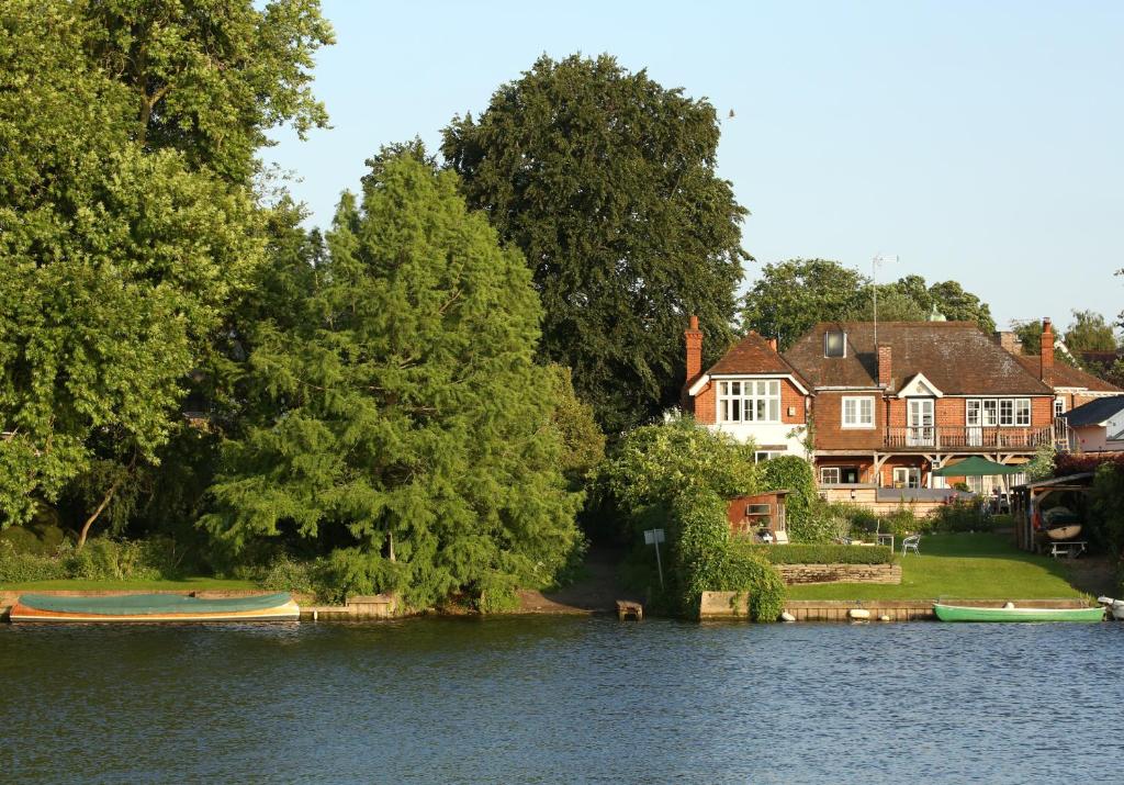 two boats on the water in front of a house at Inverloddon Bed and Breakfast, Wargrave in Reading