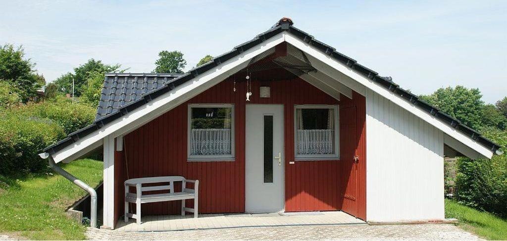 a red and white shed with a chair in it at Ferienhaus Neumann in Glücksburg