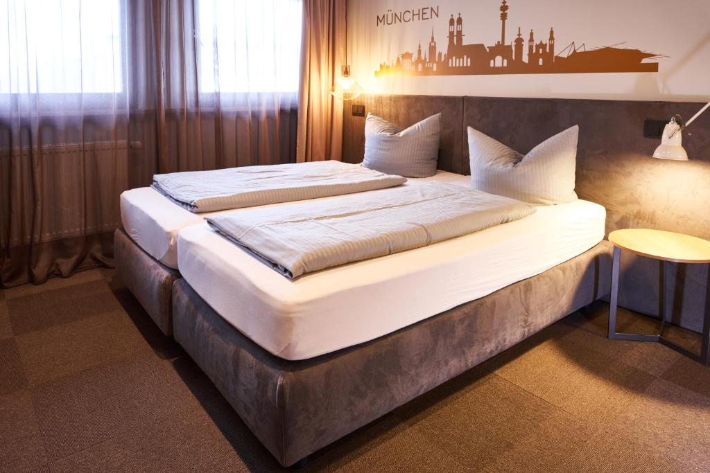 a hotel room with a bed and two lamps at Novitel Hotel Kirchheim - München Messe in Kirchheim