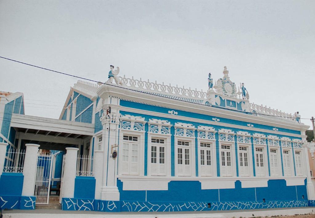 a blue and white building with people on top of it at Pousada Encantos de Palmeiras in Palmeiras