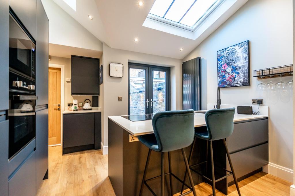 a kitchen with a counter and two chairs at a bar at Maggie's Place in York