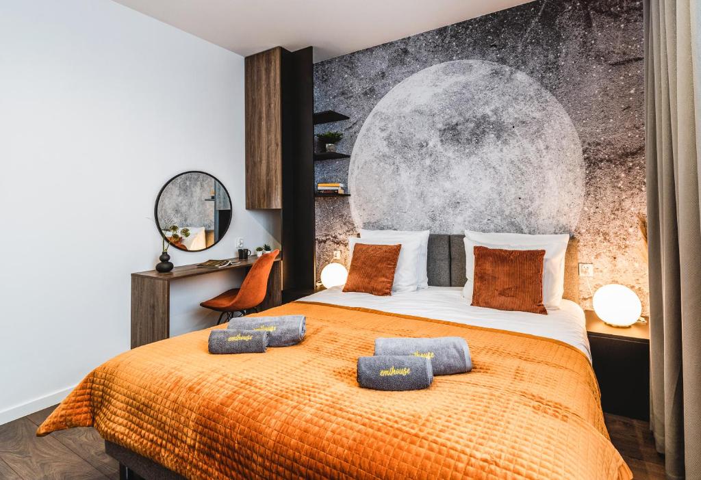sypialnia z dużym łóżkiem i pomarańczowym kocem w obiekcie Emihouse Skyline Apartments w mieście Rzeszów