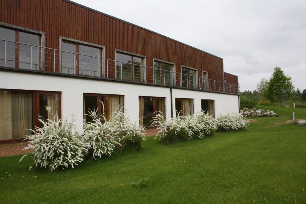 a building with white plants in front of it at Rēderi in Roja