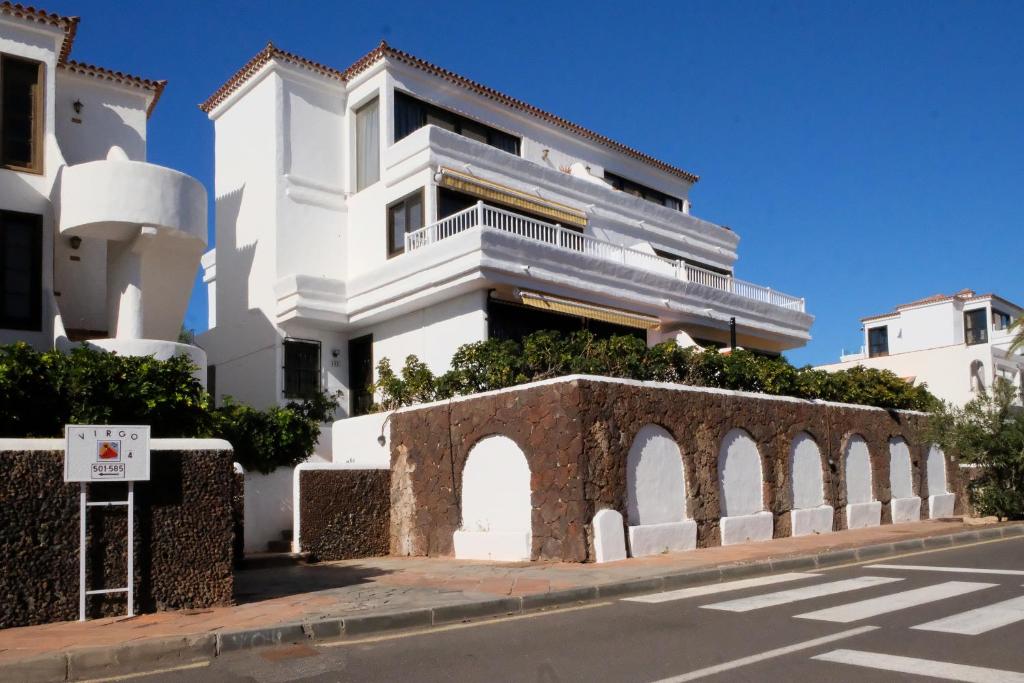 a white building with a balcony on a street at Golf Dreams in San Miguel de Abona