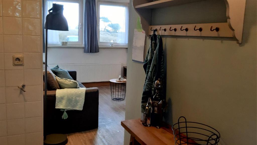 een woonkamer met een bank en een raam bij Bij De Vuurtoren in Hollum