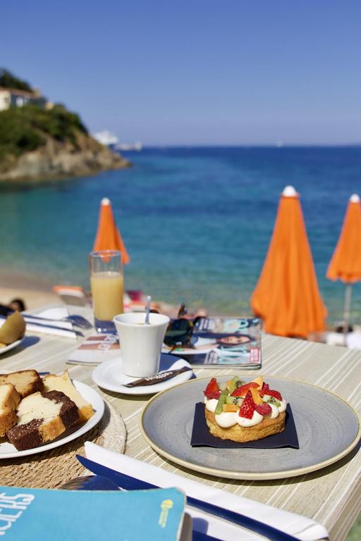 a table with plates of food on the beach at Hôtel Sampiero Corso in Propriano