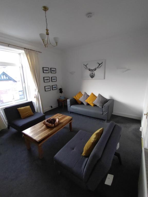 een woonkamer met 2 banken en een salontafel bij Apartment in the heart of Callander in Callander