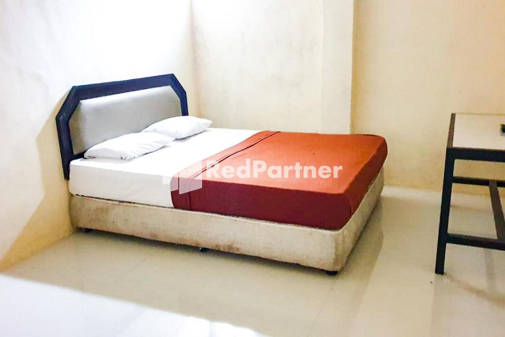 uma cama num quarto com um cartaz de parceiro em Ben Hill Bromo at Desa Wisata Bromo em Probolinggo