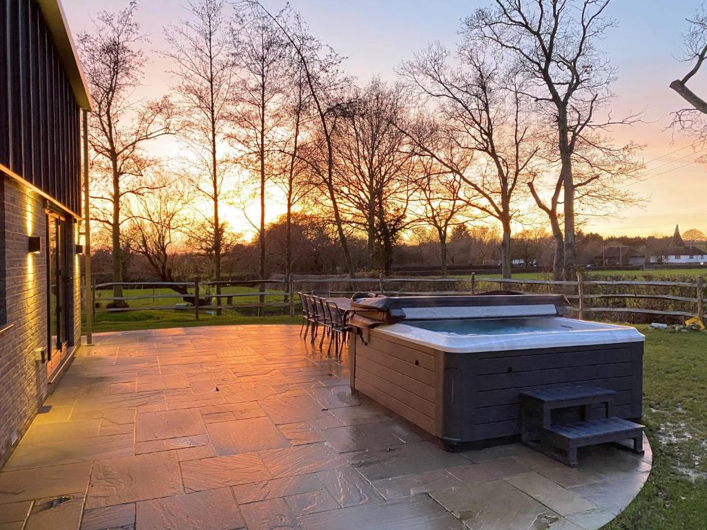 a hot tub sitting on top of a patio at Old Harrow Barn by Bloom Stays in Ashford